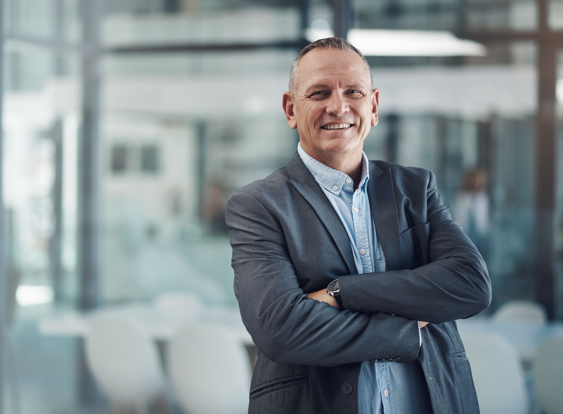 Professioneller Mann in Büroumgebung, der Vertrauen und Fachkompetenz in den Bereichen Workforce Management, Dienstplanung und Zeiterfassung ausstrahlt.