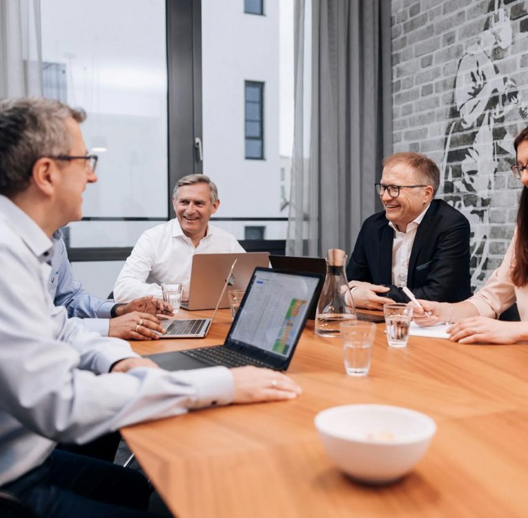 Das Führungsteam von Software4You in einer Strategiebesprechung über HR-Controlling und Workforce-Analysen mit integrierten Timegrip-Daten auf dem Bildschirm.