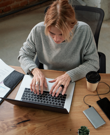 Mitarbeiterin nutzt die Zeiterfassung am Laptop, um die tatsächliche Arbeitszeit zu messen und zu analysieren.