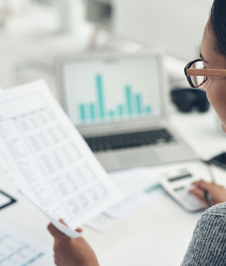 HR-Mitarbeiterin analysiert Berichte und Diagramme am Laptop im Rahmen von Workforce Management, HR Controlling, Einsatzplanung und Zeiterfassung