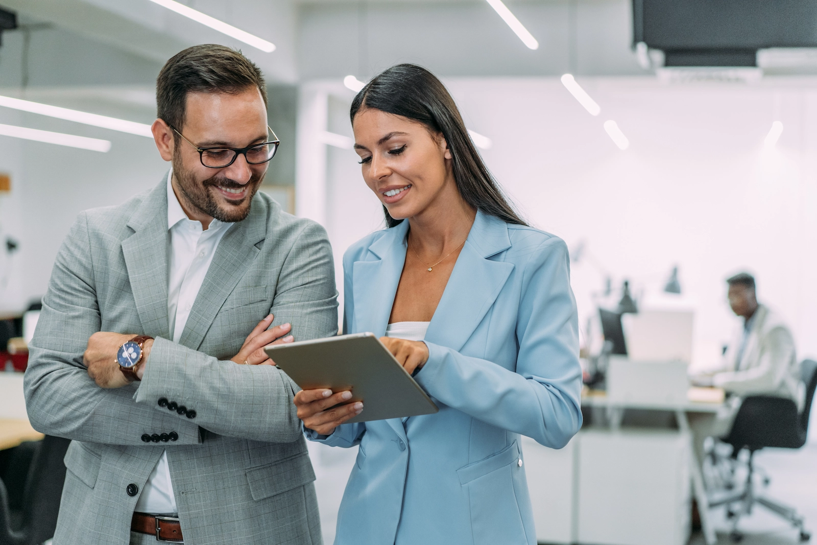 Zwei Fachkräfte analysieren Personaldaten auf einem Tablet und zeigen Zusammenarbeit bei digitaler Schichtplanung und mobiler Einsatzsteuerung.